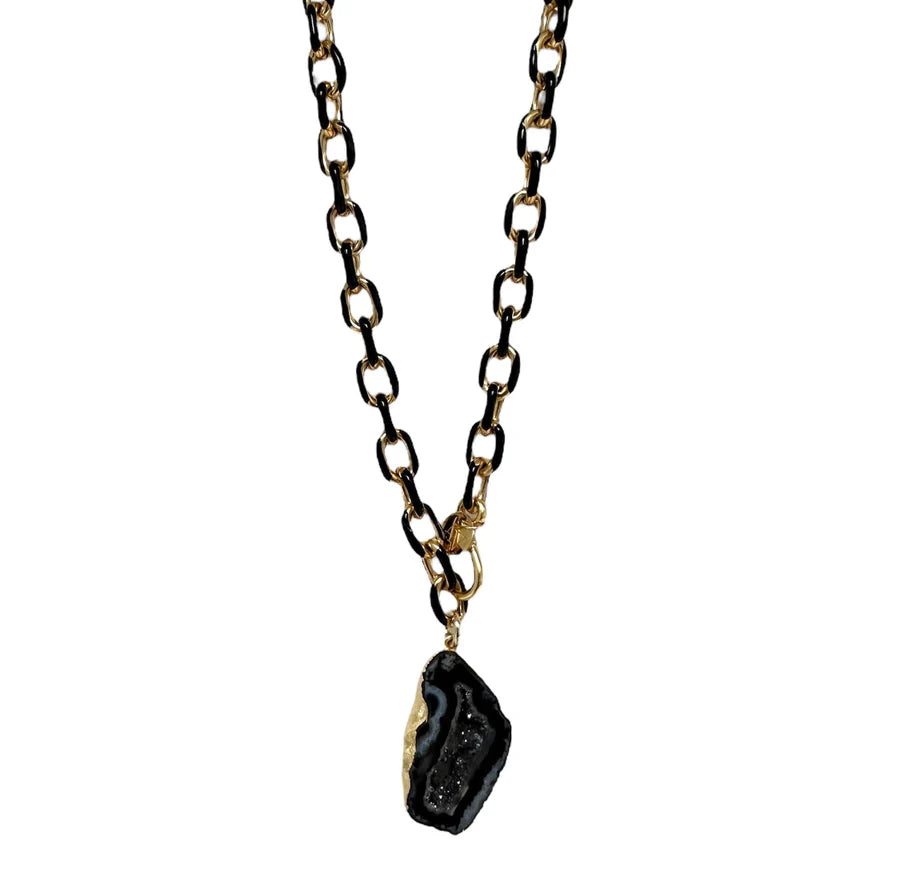 The Eclipse Necklace by Aria V is a handmade Irish piece featuring large black and gold chain links and a striking black geode pendant trimmed in gold for a bold, modern look.
