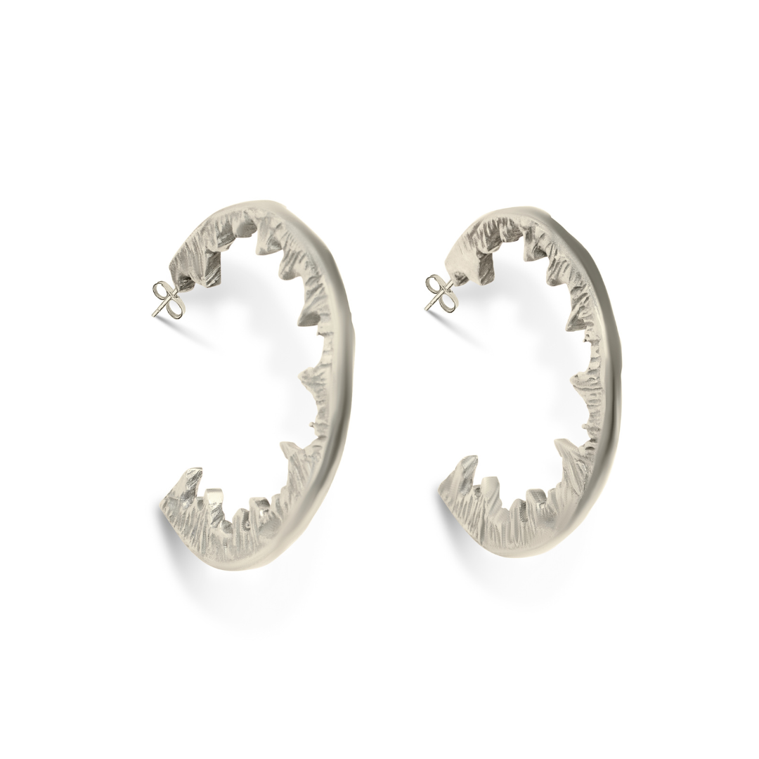 Element Hoops by Madeleine Sculptural Jewellery: striking silver earrings shaped like open jaws with jagged teeth, shown on a white background—ideal for fans of bold, handmade jewellery.