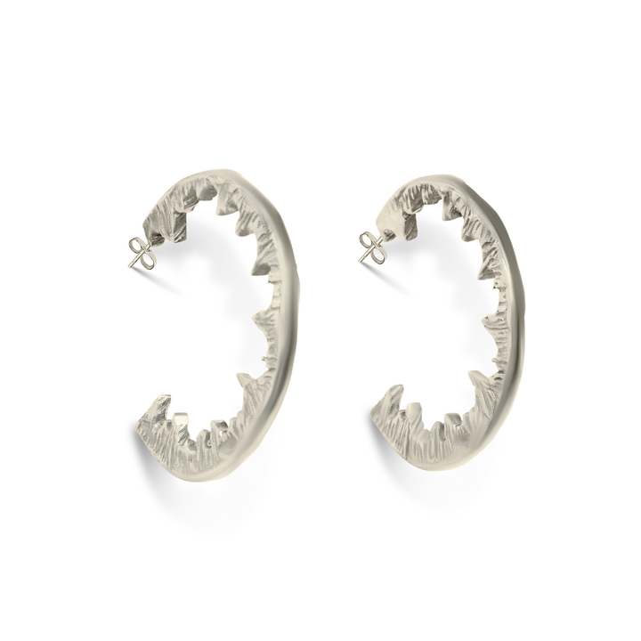Element Hoops by Madeleine Sculptural Jewellery: striking silver earrings shaped like open jaws with jagged teeth, shown on a white background—ideal for fans of bold, handmade jewellery.