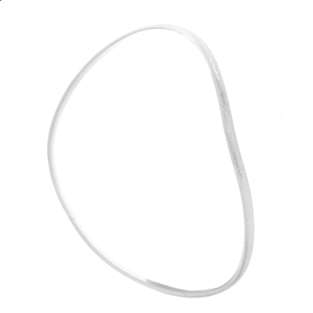 A thin, irregularly shaped sterling silver bangle with a smooth finish, showcasing its handmade charm. The **Ellipse Bangle Silver** by **Aud** has a slightly uneven, organic form against a plain white background.