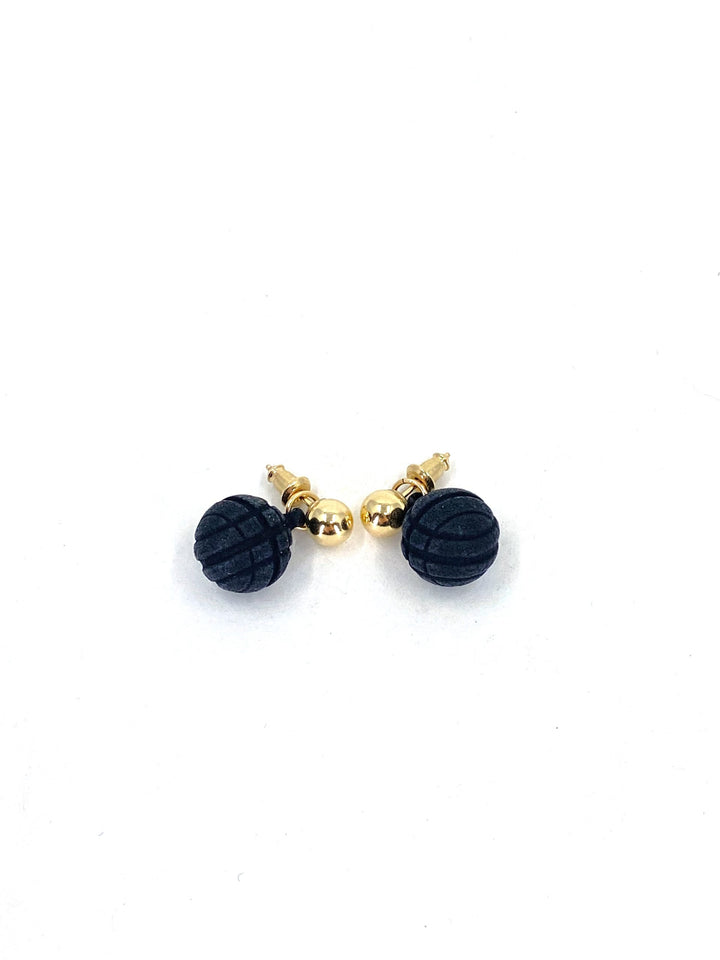 A pair of small, 3D printed black Vibe 2 Ball Stud Earrings by Elsiem with 14K gold-filled backs and posts. The black portions have a spherical shape with a grooved texture. The earrings are displayed against a plain white background.