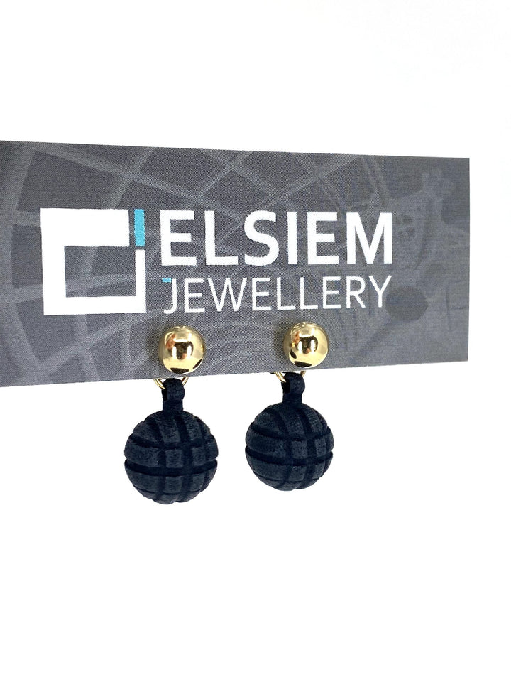 A pair of black textured dangling earrings, made from lightweight material, is attached to a card displaying the brand name "Elsiem." The Vibe 2 Ball Stud Earrings have a spherical design with 14K gold-filled studs set against the plain white background.