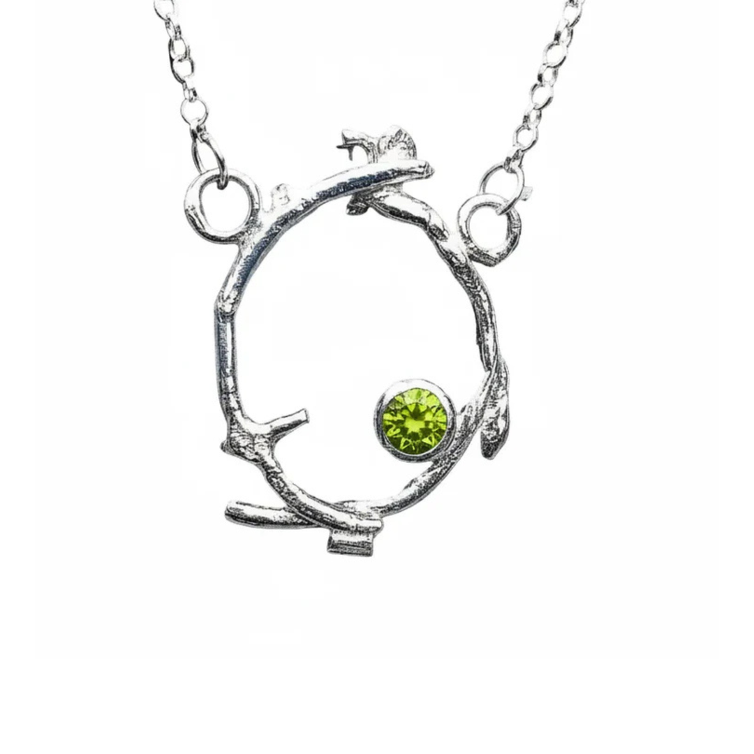 The Faerie Crown Pendant Peridot by Caroline Stokesberry-lee features a circular twig-shaped silver pendant with a round Peridot gemstone, hanging from two loops on a delicate sterling silver chain.