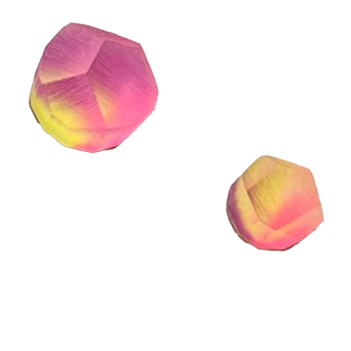 Two brightly colored, multifaceted shapes are displayed against a plain white background. The shapes exhibit a gradient of pink, yellow, and orange hues reminiscent of gold-plated jewelry. The larger shape is positioned in the top left, while the smaller shape sits in the bottom right. These vibrant forms are part of the Fruit Bijoux Ring Top Aura by Fruit Bijoux.