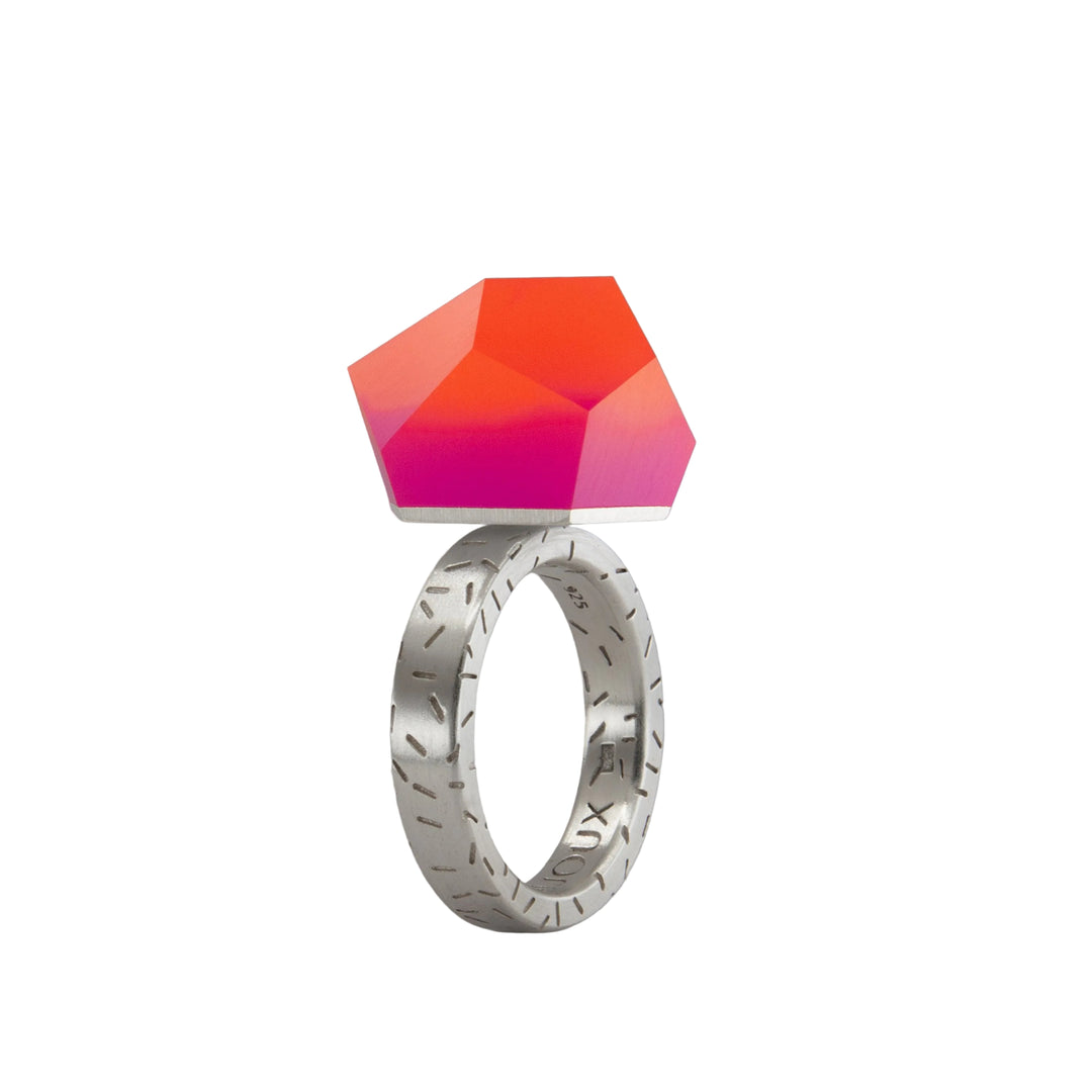 The Fruit Bijoux Ring Top VU Crystals Sunset Pink by Fruit Bijoux features engraved silver details and a large, faceted geometric VU Crystals gemstone in a striking Sunset Pink gradient that transitions beautifully from red to pink.
