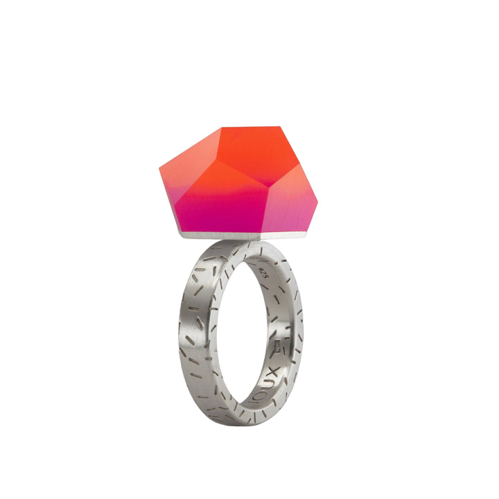 The Fruit Bijoux Ring Top VU Crystals Sunset Pink by Fruit Bijoux features engraved silver details and a large, faceted geometric VU Crystals gemstone in a striking Sunset Pink gradient that transitions beautifully from red to pink.