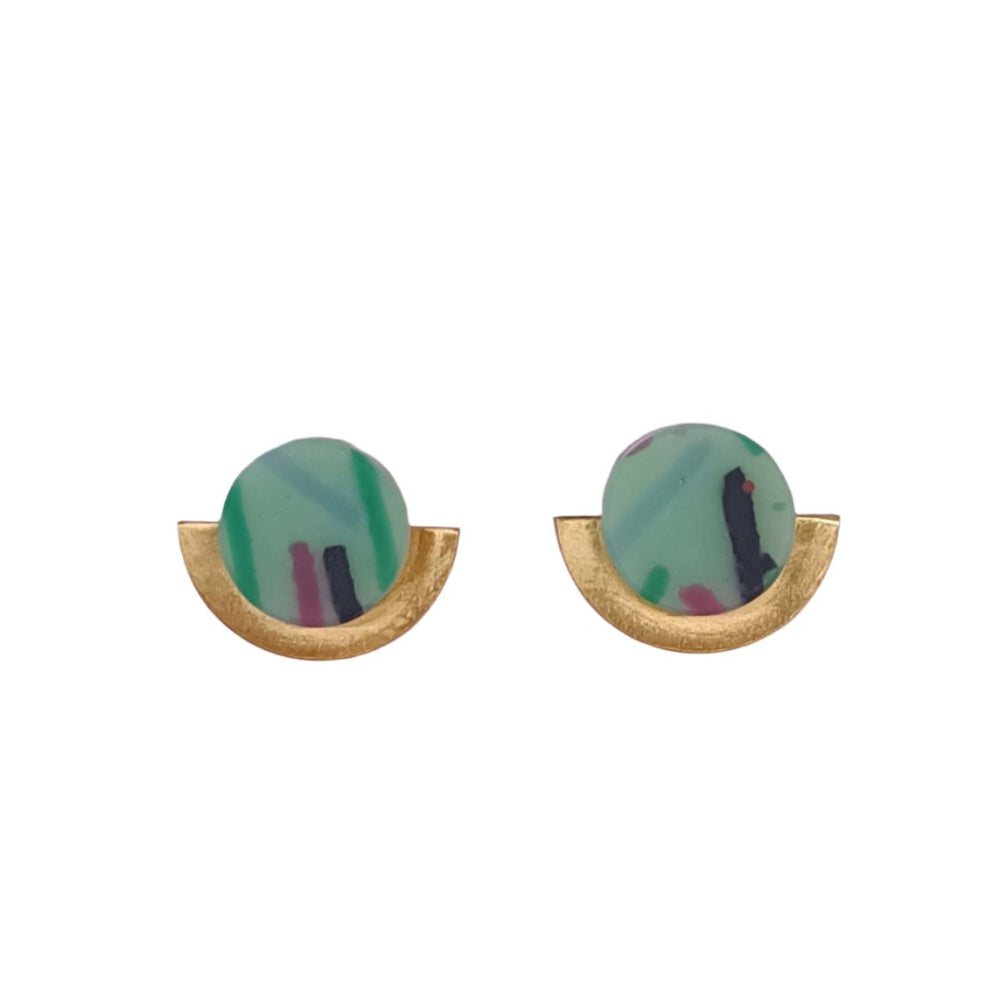 The Funfetti Gold Short Earrings by Beira, designed by Irene Reyes, feature round, marble-patterned stones in shades of green, teal, black, and pink set in semi-circular matte gold-colored metal bases. The overall design resembles a half-moon shape crafted from recycled bottle glass.