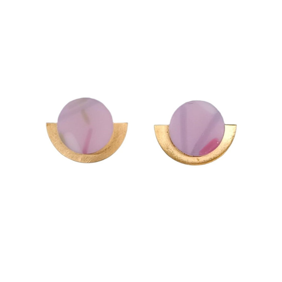 A pair of Funfetti Gold Short Earrings from Beira by Irene Reyes, showcasing round, translucent purple stones set in 18 carat gold semi-circle bases. The design is simple and elegant, combining the soft hue of the stones with the metallic shine of the gold. The earrings are displayed against a plain white background.