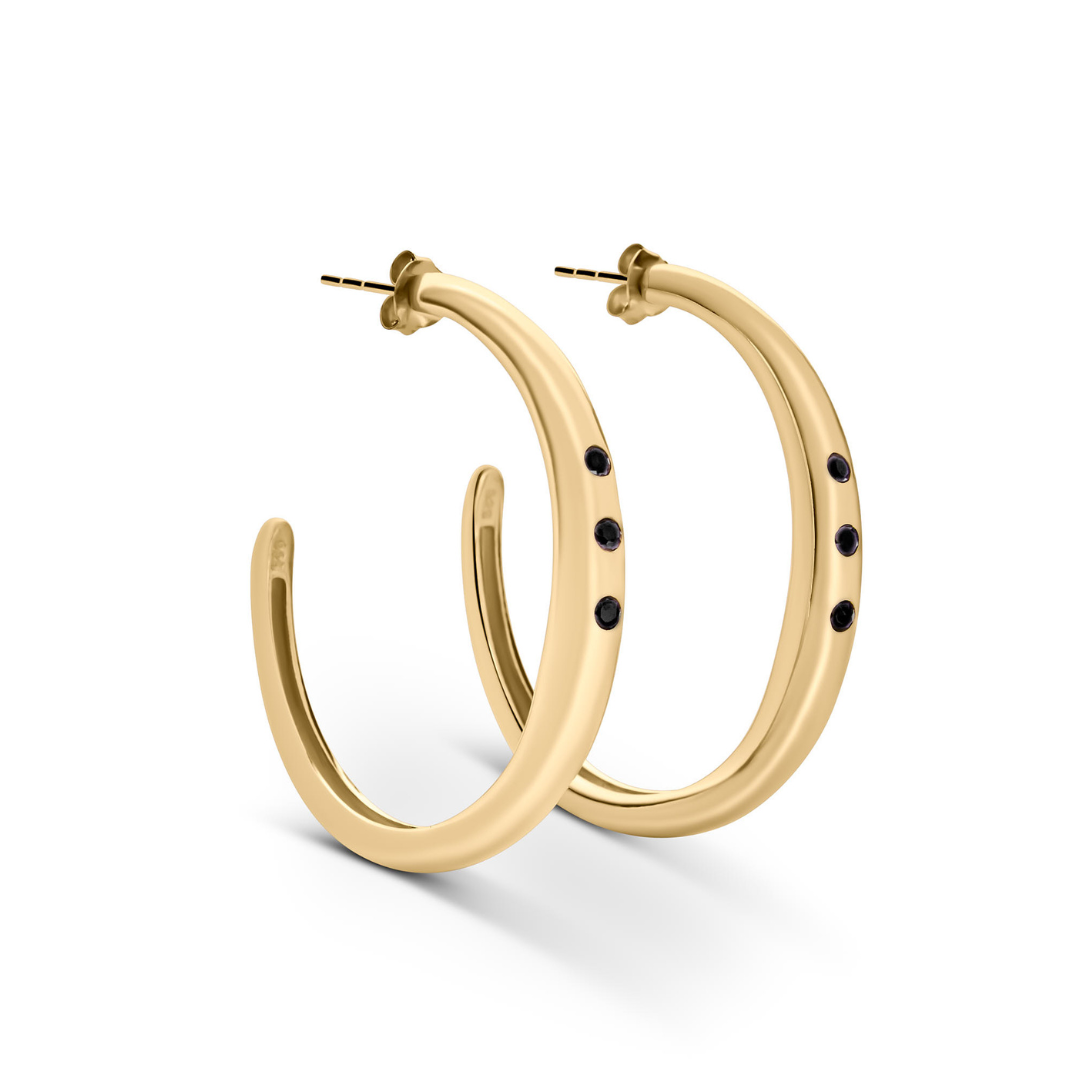 The Cualli Hoops by Gallardo & Blaine Designs feature gold plated sterling silver and three small black spinel gemstones on each hoop, displayed against a white background.