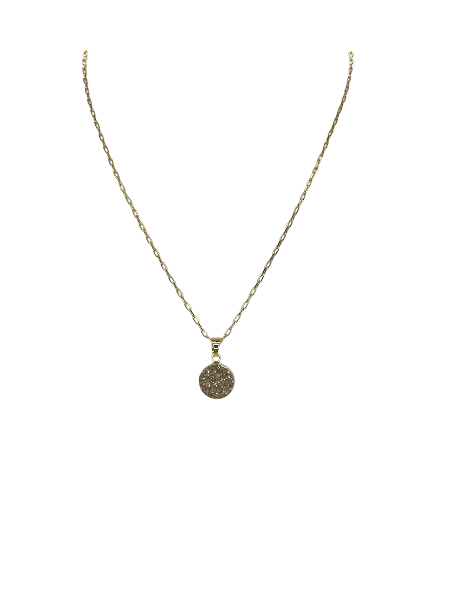 The Gigi Necklace by Aria V features a delicate gold-plated chain with a round, textured Druze pendant at its center, showcased against a plain white background.