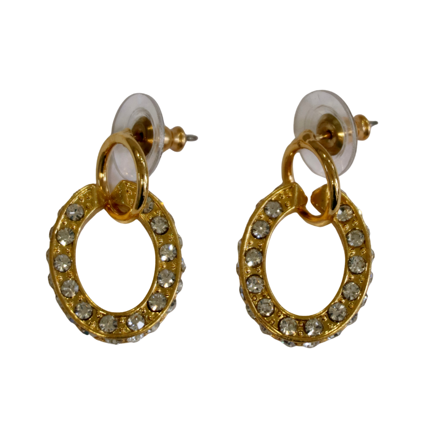 Zubeldia Gold Plated Crystal Oval Earrings feature clear rhinestones set in a gold plated design, each secured with a clear plastic backing.