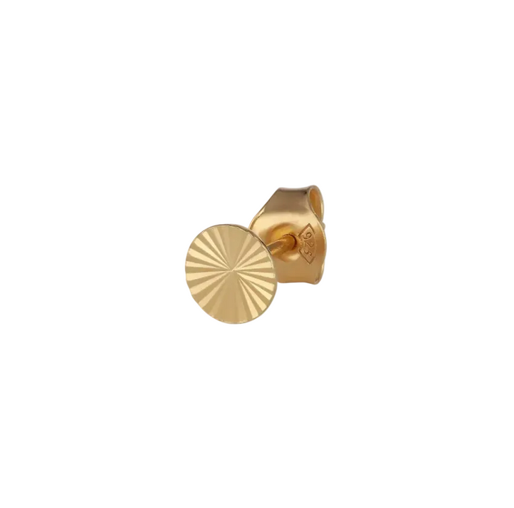 A gold embossed round stud earring on a plain white background.