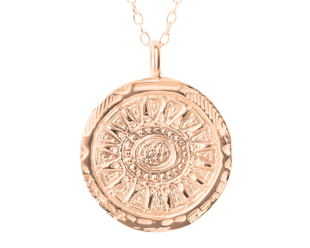 The Ava Jane Jewellery Sunbeam Pendant Gold features a round, gold-plated pendant with an intricate sunburst pattern and raised center, shown on a plain white background.