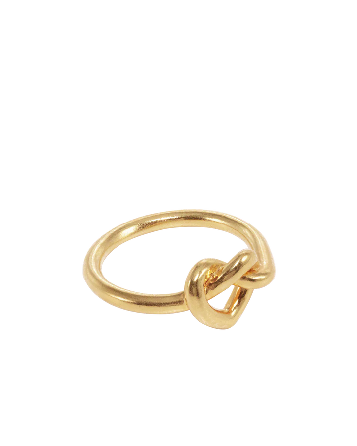 The Jane Koenig Tied Heart Ring is a gold ring with a simple knot detail at the center, shown on a plain white background.