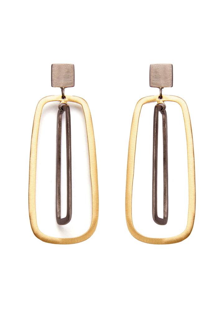 A pair of Grafton Black & Gold Earrings by The Collective Dublin showcasing a modern, geometric drop design with a rhodium-plated silver square at the top, a golden rectangular frame, and a long, slender black inner rectangle. These earrings offer a minimalist and contemporary look.