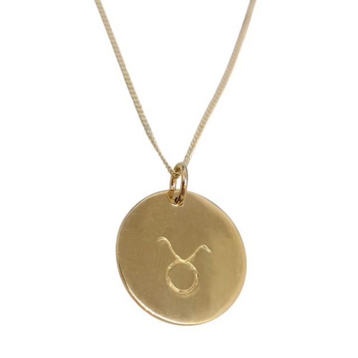 The Handstamped Horoscope Necklace by Personalised Charms features a gold disc engraved with the Taurus symbol, making it a perfect gift for astrology lovers.