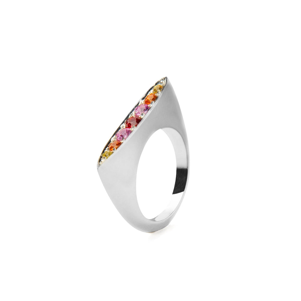 A sleek sterling silver ring with a modern, angular design. The top edge is adorned with a row of small vibrant sapphires in shades of yellow, orange, and pink, which elegantly contrast with the smooth, reflective metal surface. Introducing the Morningstar Sapphire Ring by Cosmic Boulevard.