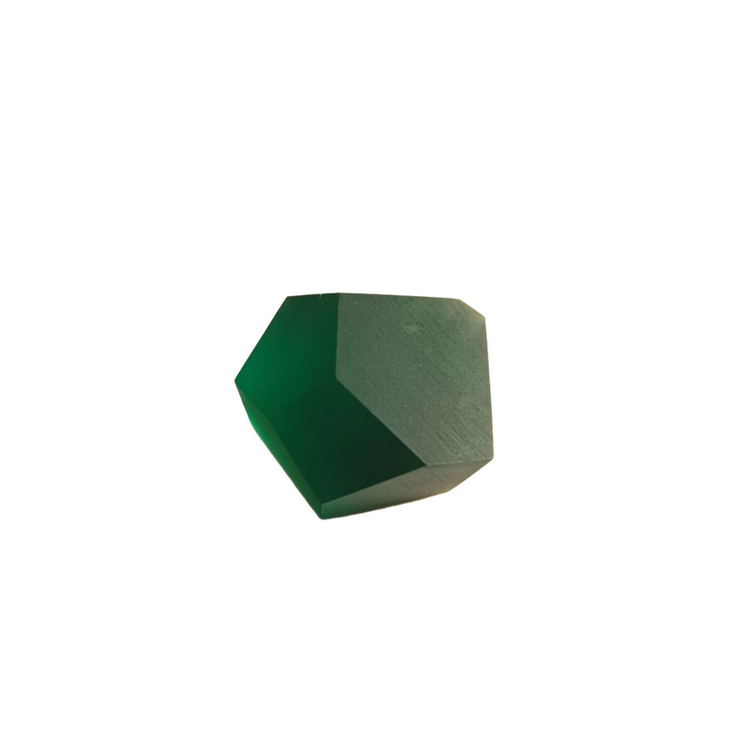 A green, multifaceted geometric object lies on a textured white surface. It has a mix of light and shadow, creating a gradient effect. The object has a three-dimensional appearance, reminiscent of the Fruit Bijoux Ring Top VU Crystals Emerald Green by Fruit Bijoux, with lighting emphasizing its various flat surfaces and angles.