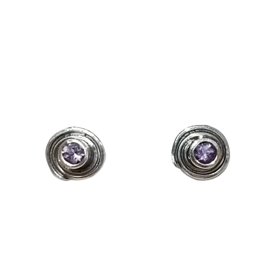 The Amethyst Sun Seeker Spiral Stud Earrings by Caroline Stokesberry-lee. Inspired by ancient Ireland, these stunning earrings are displayed in a white padded jewelry box.