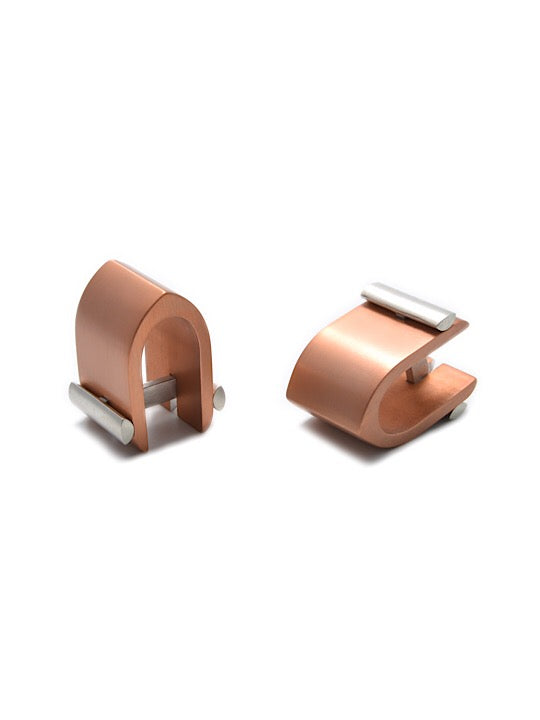 A pair of Filip Vanas Ogive Wrap Around Cufflinks. Each cufflink features a curved, polished bronze arch with horizontal sterling silver bars, creating an innovative concept that is both modern and sophisticated, perfect for formal wear.