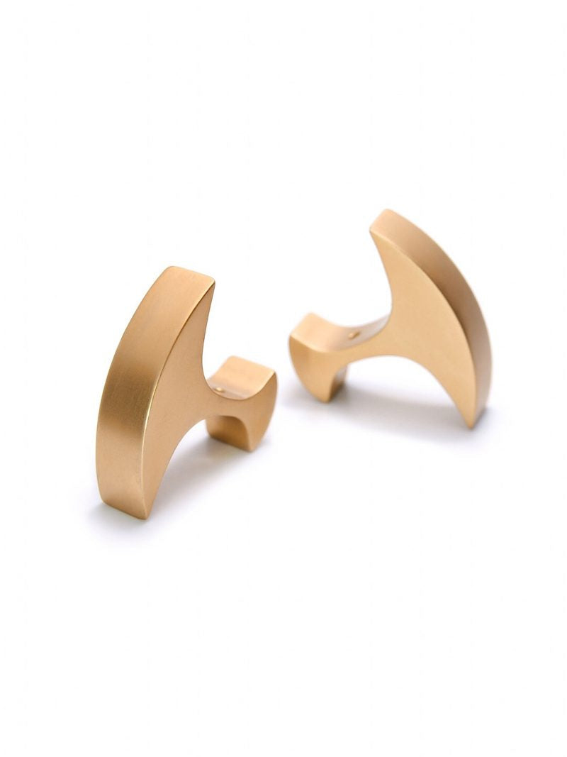 A pair of Secant Cufflinks by Filip Vanas, crafted with smooth, curved shapes in anodized aluminium. The matte finish adds to their sleek appeal, and the cufflinks are positioned at slightly different angles against a white background. These modern accessories are perfect for any sophisticated wardrobe.