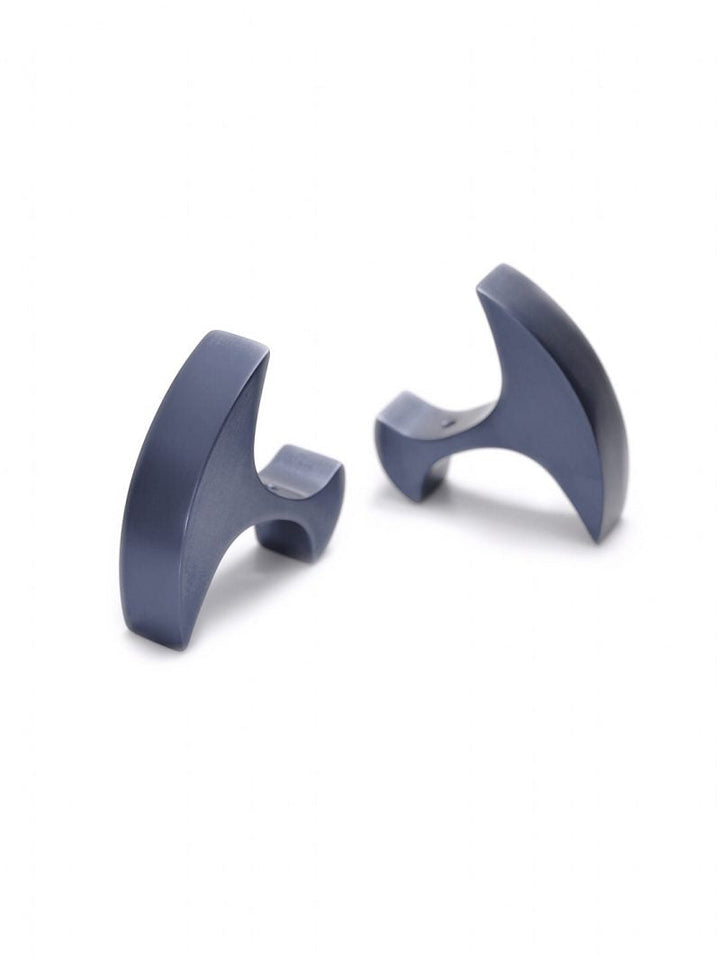 A pair of modern, matte dark blue cufflinks with a unique, curved design. Each cufflink features a sleek, sculpted form in anodized aluminium that combines geometric shapes and smooth lines, creating an eye-catching, artistic accessory suitable for formal attire. The Secant Cufflinks by Filip Vanas effortlessly blend contemporary style with timeless elegance.