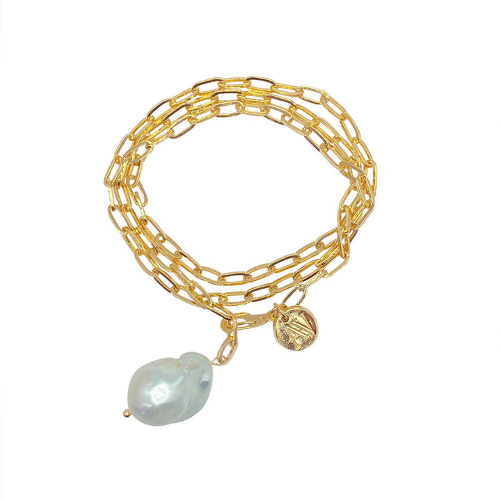 Aria V's Medea Necklace/Bracelet features elongated 16k gold electroplated links wrapped three times, adorned with a large baroque white pearl charm and a small gold coin charm.