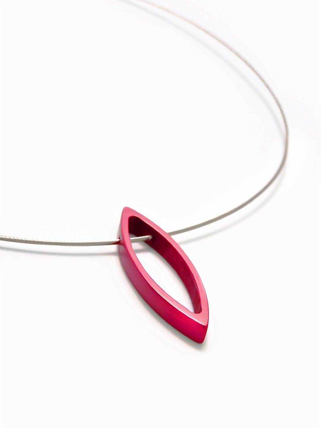 A minimalist necklace with a thin, stainless steel cord features the Filip Vanas Small Navette Pendant. The anodised aluminium pendant is modern and sleek, creating a contemporary and elegant look against the white background.