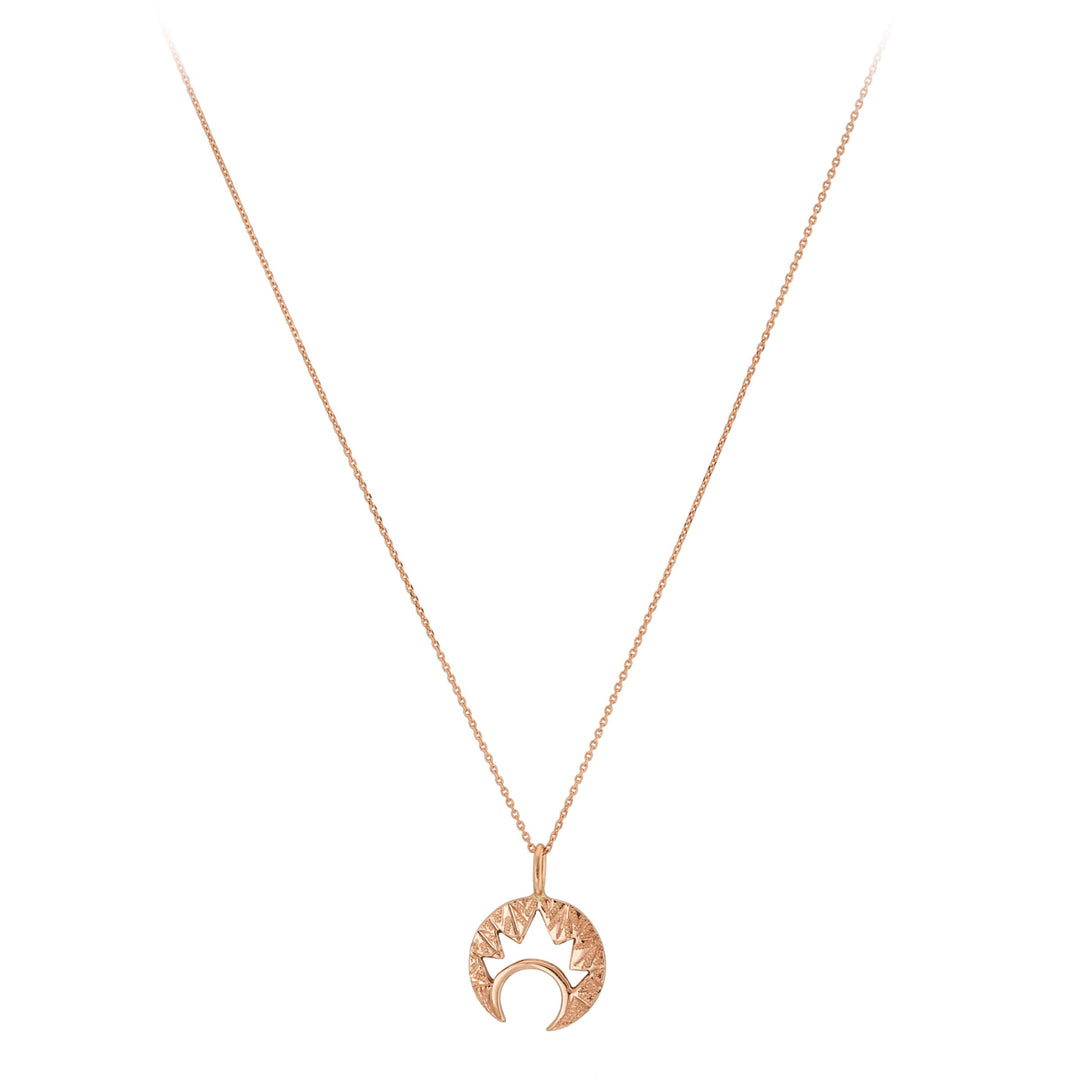 The "Moon & Moon" 9ct Gold Pendant by Cosmic Boulevard is a delicate necklace featuring a crescent moon pendant in both yellow and rose gold, adorned with a sunburst design on top. The thin, elegant chain enhances the unique and stylish pendant that combines celestial themes with intricate hand-engraved details.