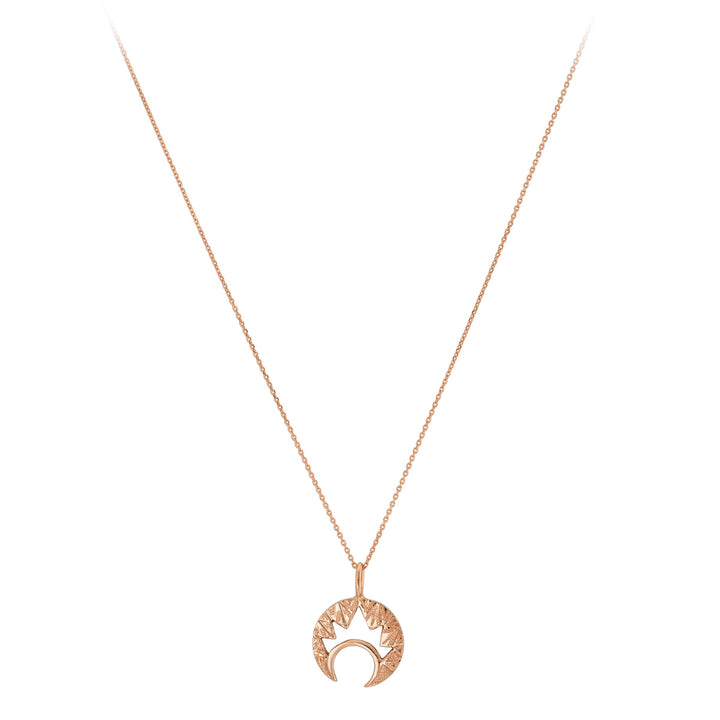 The "Moon & Moon" 9ct Gold Pendant by Cosmic Boulevard is a delicate necklace featuring a crescent moon pendant in both yellow and rose gold, adorned with a sunburst design on top. The thin, elegant chain enhances the unique and stylish pendant that combines celestial themes with intricate hand-engraved details.