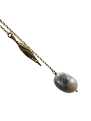 The Gathered Forms Lariat Necklace by Inner Island is a gold vermeil lariat with a leaf-shaped charm and a large baroque pearl pendant.