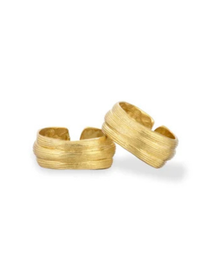 Two Strata Rings by Inner Island, featuring textured gold with parallel engraved lines, are displayed on a white background, one ring slightly overlapping the other.