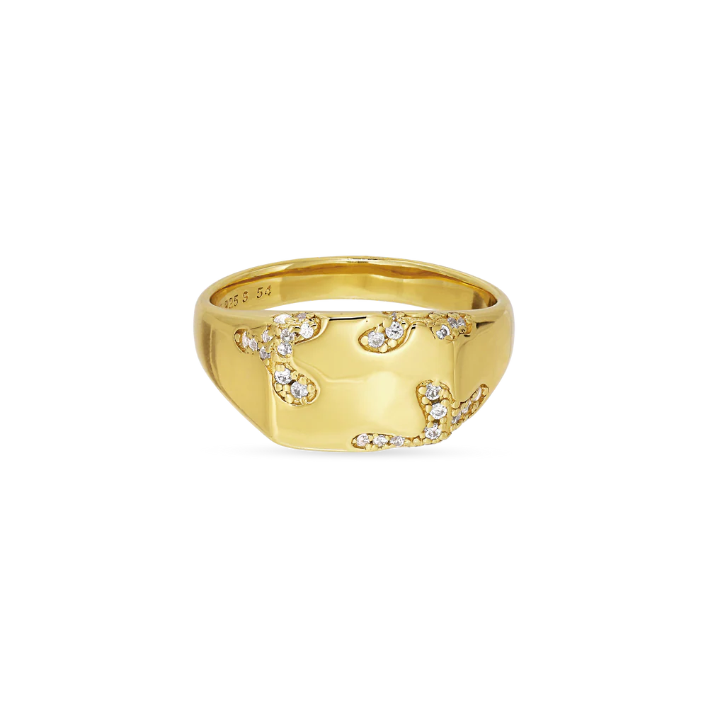 The Iced Signet Ring by Jane Koenig is a gold-plated ring with a wide band, adorned with small, white sparkling stones in an abstract swirling pattern, offering a stunning and modern look.