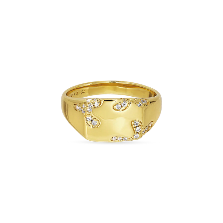The Iced Signet Ring by Jane Koenig is a gold-plated ring with a wide band, adorned with small, white sparkling stones in an abstract swirling pattern, offering a stunning and modern look.