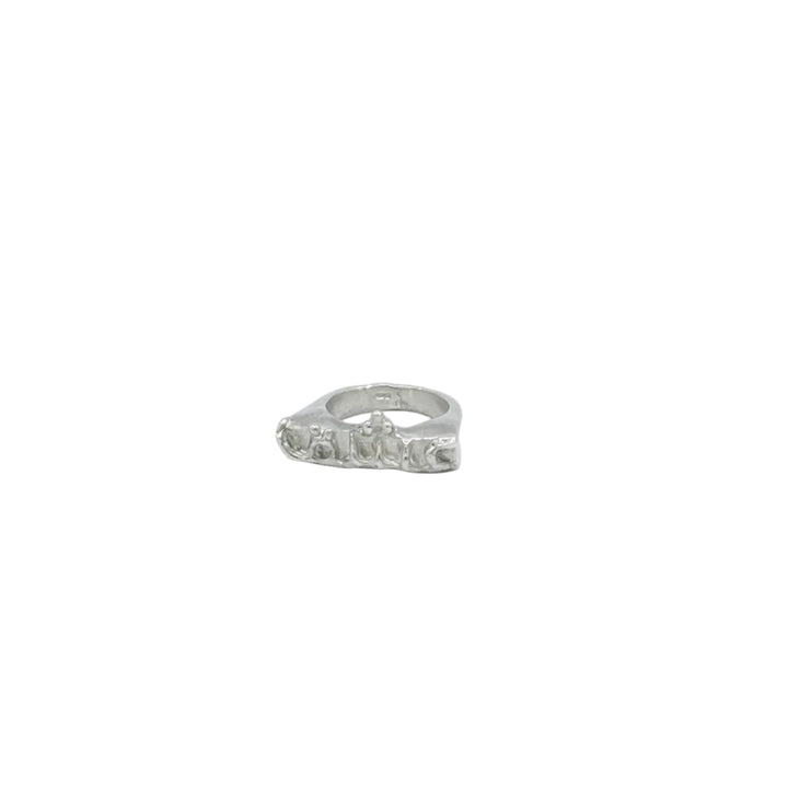 The Ishq Ring by Soufana Attia—a silver ring with an irregular, sculpted design symbolizing endless love—rests on a plain white background.