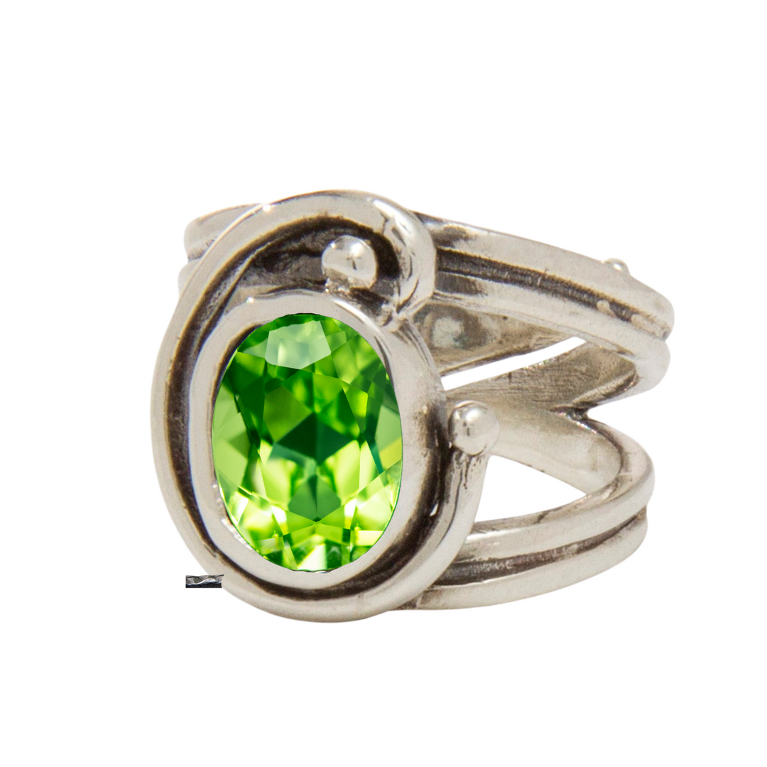 The Adjustable Jasmine Ring by Gallardo & Blaine Designs features an Art Nouveau-inspired silver band that elegantly intertwines to cradle a beautiful oval green gemstone.