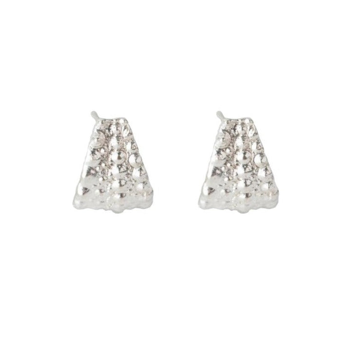 A pair of small, triangular-shaped, silver earrings with a textured, bubble-like surface. These Sea Urchin Wrap Stud Earrings by Jennifer Kinnear have a modern and minimalist design, showcasing a subtle metallic shine against a white background.