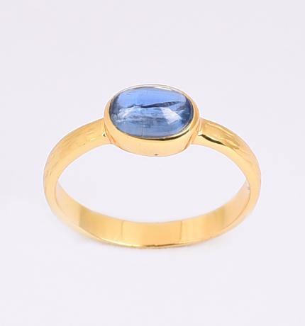 A gold-plated sterling silver ring with a slender band features an oval blue gemstone set in a bezel setting. The polished Kyanite Gold Ring from Watermelon tropical has a smooth surface. The simple ring set is displayed on a plain white background.
