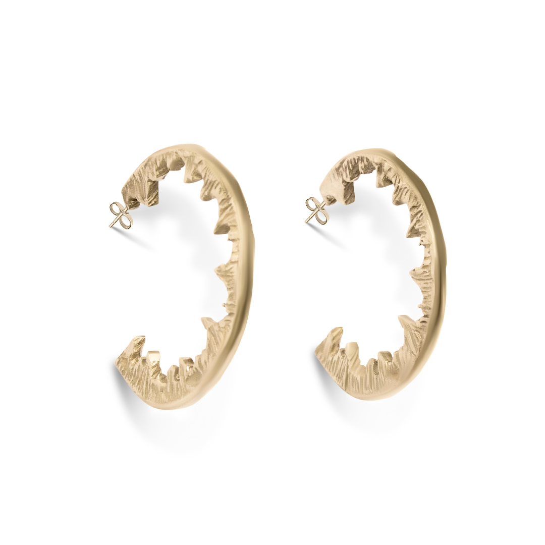 Element Hoops by Madeleine Sculptural Jewellery: bold, handmade gold statement earrings shaped like open jaws with jagged teeth, displayed against a white background—perfect for those who love to stand out.