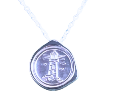 The My Guiding Light Silver Pendant by Ava Jane Jewellery features a sterling silver round charm with an engraved lighthouse on a delicate chain, making it a sentimental gift—shown on a plain white background.