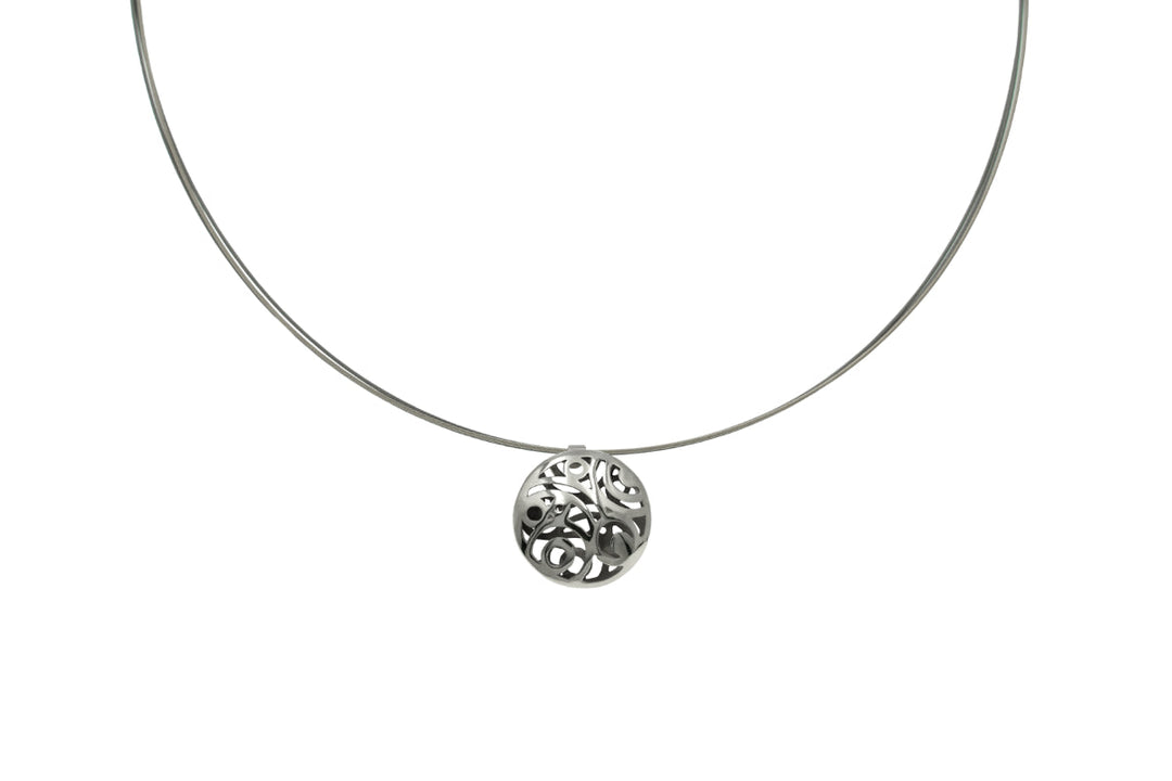 A minimalist necklace featuring a thin, silver wire with Líos Silver Pendant on Steel Cable at the center. Inspired by historical monuments jewelry, Miriam Wade's pendant has an openwork pattern with swirls and curves, creating a delicate and elegant look.