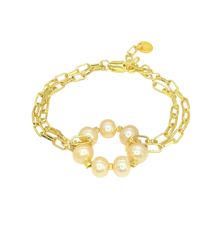 The Lunaire Pearl Bracelet by Aria V features two layered gold chains and a central ring adorned with six pink freshwater pearls, shown on a plain white background.