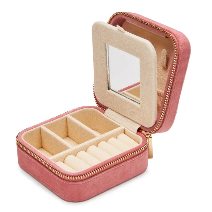 A small, open, Luxurious Pink Velvet Travel Jewellery Box by SoCases with a gold zipper. Perfect for travel jewellery storage, it features several compartments for rings and accessories and has a built-in mirror on the inside of the lid. The interior is lined with beige velvet.