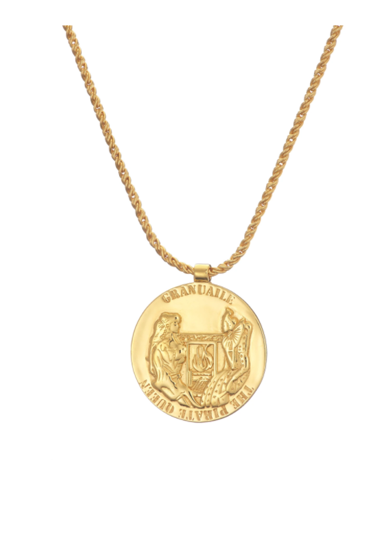 The Grace O'Malley Medallion Small necklace in silver, gold, and black by Jennifer Kinnear features a gold-plated medallion pendant with an engraved design of two figures and a shield. The medallion, hanging from a twisted chain, bears the inscriptions "GRANUAILE" and "N GRÁINNE MHAOL," evoking the legacy of Queen Elizabeth I's era.