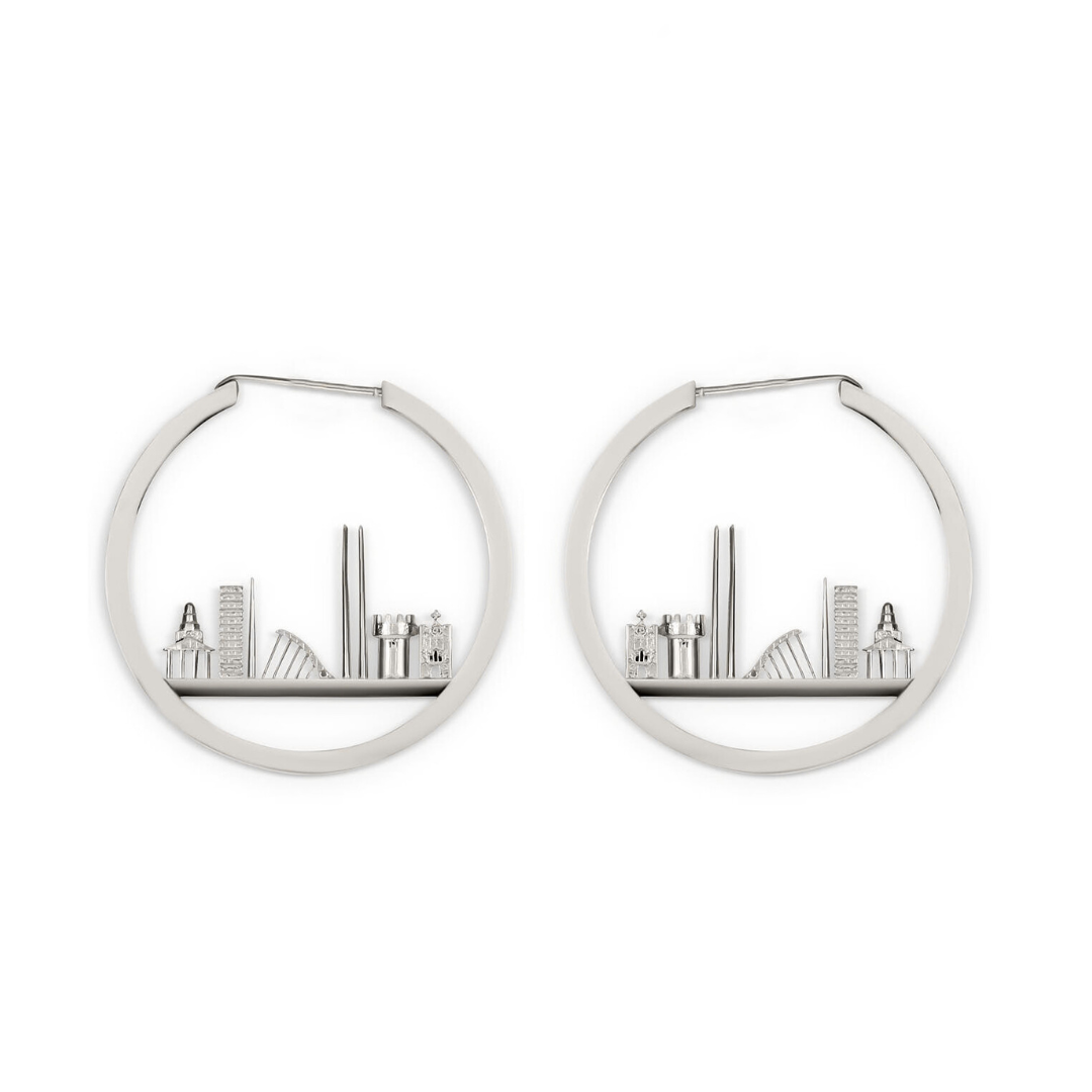 The Horizon of Dublin Hoops by Madeleine Sculptural Jewellery are silver hoop earrings with tiny books and bookshelf decor arranged inside each handcrafted, miniature bookshelf design.