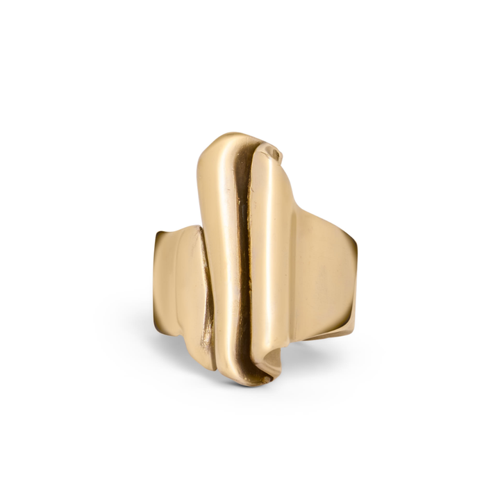 The Tonnach Ring Big by Madeleine Sculptural Jewellery features a wide gold band with an abstract, folded center design, showcasing hand-carved artistry. Photographed on a white background.