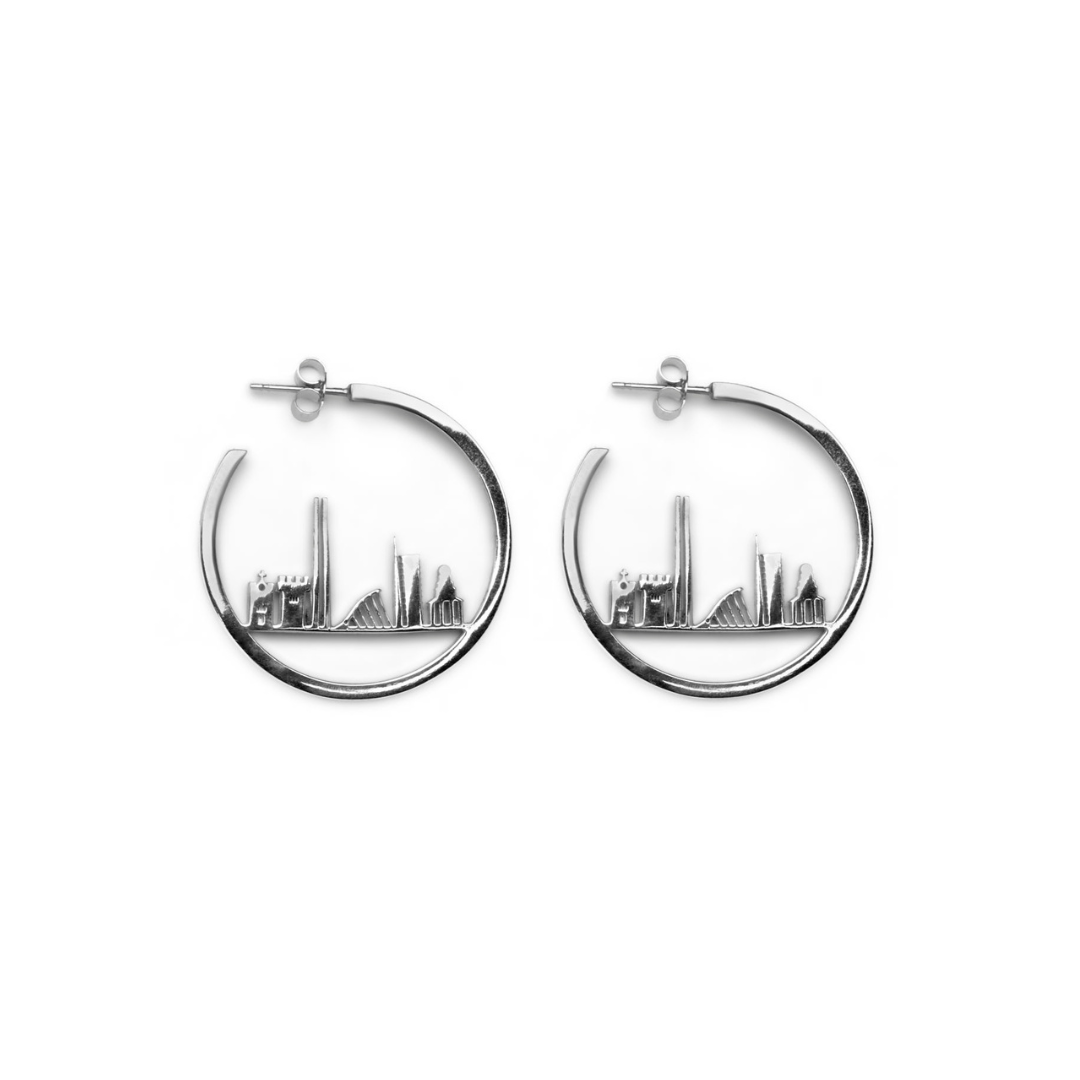 Horizon of Dublin Hoops by The Collective Dublin are silver hoop earrings featuring a city skyline design within each hoop, expertly handcrafted as sustainable jewellery and showcased on a white background.