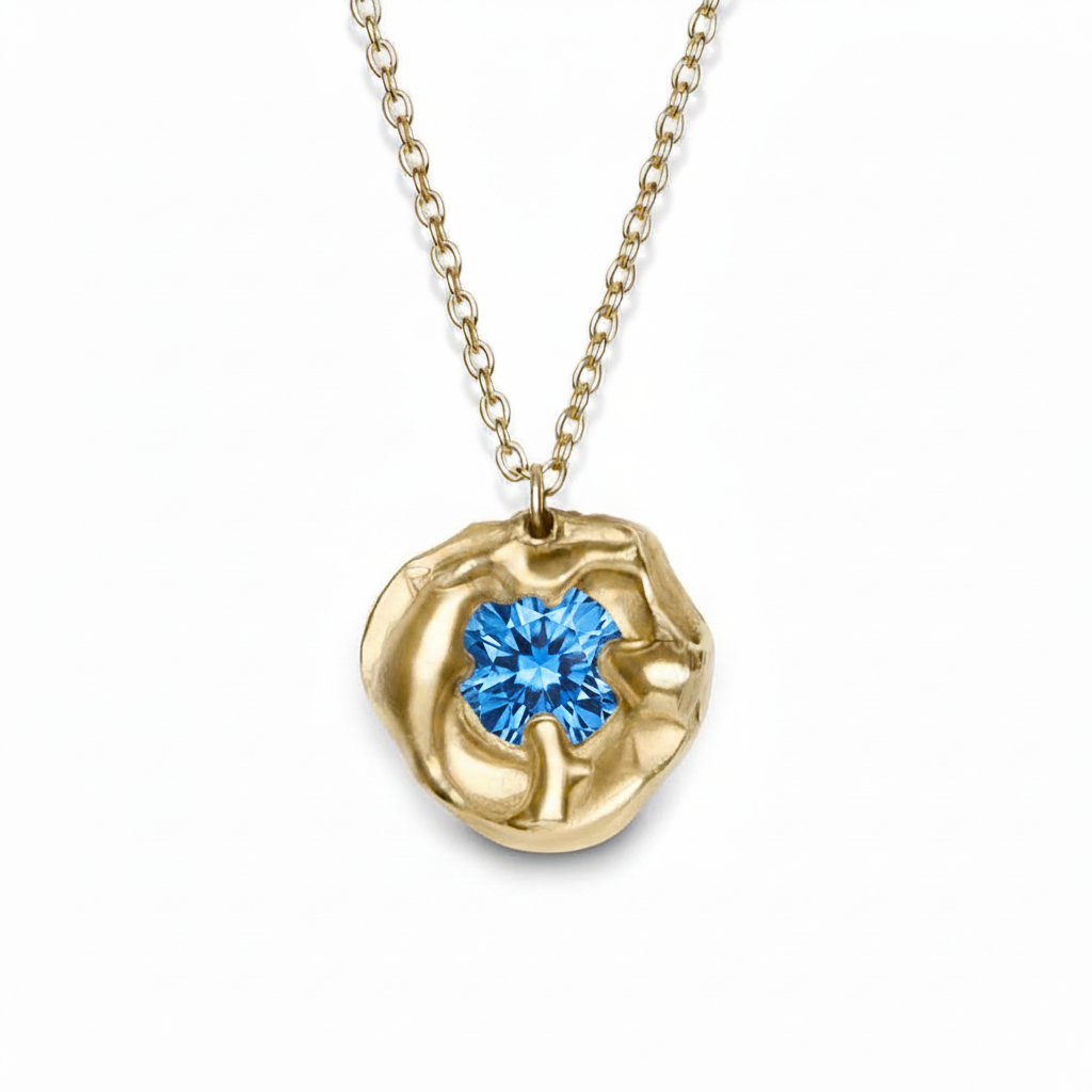 The Molten Necklace with Moissanite by Madeleine Sculptural Jewellery features an organic, sculpted gold circle set with a sparkling moissanite gemstone on a fine gold chain—a striking handmade piece.