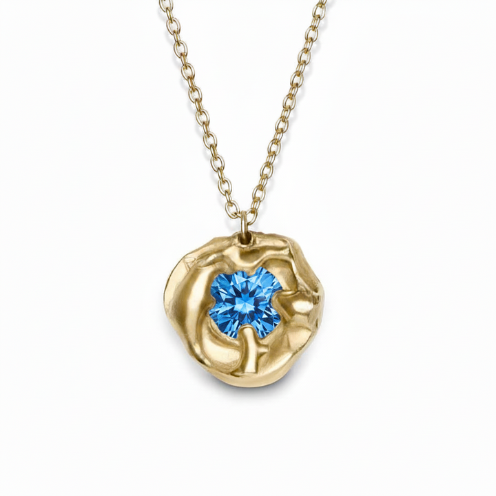 The Molten Necklace with Moissanite by Madeleine Sculptural Jewellery features an organic, sculpted gold circle set with a sparkling moissanite gemstone on a fine gold chain—a striking handmade piece.