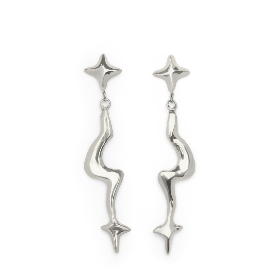 The Nova Earring Large by Madeleine Sculptural Jewellery features a pair of shiny, silver drop earrings with abstract, wavy stems and star-shaped motifs at both the top and bottom of each earring, displayed on a white background.
